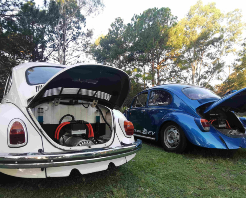 The white 1971 electric Super Beetle and Traction EV's 1968 Shop Beetle in 2021. Rear view showing the HyPer9 electric motors and speed controllers.